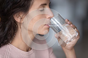 Close up of thirsty woman drink water from glass