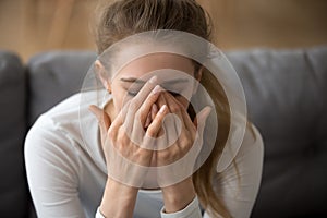 Close up thoughtful woman covered face in hands, feeling pain