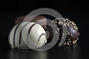 Close up of three chocolate bonbons, white dark and milk chocolate. Sweet, calorie-rich and energy-rich food with unhealthy and fa