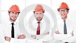 Close up.three confident business men in protective helmets