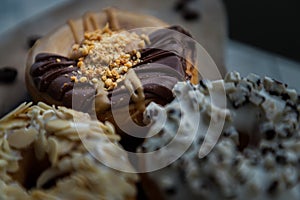 Close-up of Three doughnuts covered with Choco peanut butter, Cookies and creme and Almendras photo