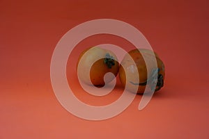 Close up of three fresh tomatoes isolated on an orange background. Food High in Vitamins and very healthy