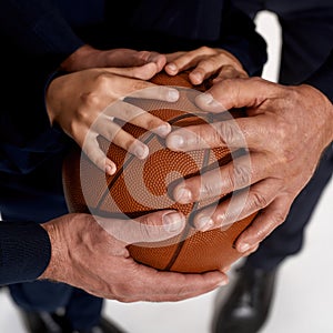 Close up of three generations of sportsmen hands on ball