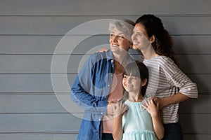 Close up three generations of women dreaming, looking to aside