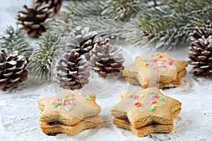 Close up of three traditional bulgarian star shaped, double honey cookies Medenki, with jam filling and colorful sugar sprinkles