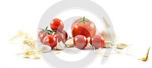 Close up of three types of tomatoes - big red, long and cherry and garlic on a white background