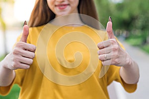 Close up of thumbs up young and beautiful caucasian girl. Agreement sign.