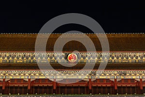 Close-up of Tiananmen Gate with archiectural details and national emblem of China at night, in Beijing, China