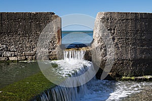 Close up of tide pool wall with waves of sea water - abstract creative background