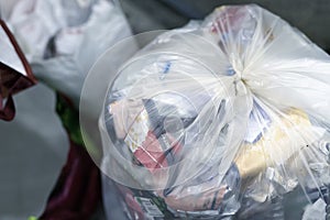 Close-up tied full household plastic waste bag filled with non-recyclable rubbish at recycling acceptance collection