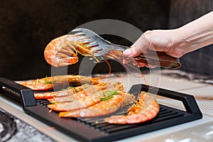 Close-up. Tiger prawns are fried on an electric grill in the kitchen.