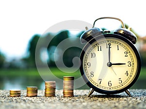 Close up of time and stack money coins, time value of money concept in business finance theme. Saving money for future