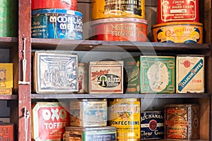 Close-up of tins of vintage dry goods on wooden shelves in general store