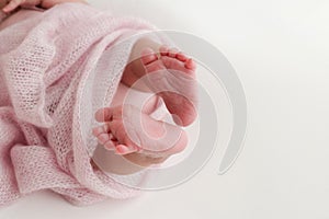 Close-up of tiny, cute, bare toes, heels and feet of a newborn girl, boy. Baby foot on pink soft