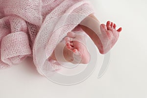 Close-up of tiny, cute, bare toes, heels and feet of a newborn girl, boy in pink