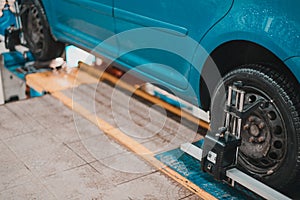 Close-up of a tire clamped by a leveler that passes the automatic alignment of the wheels in the garage, garage and