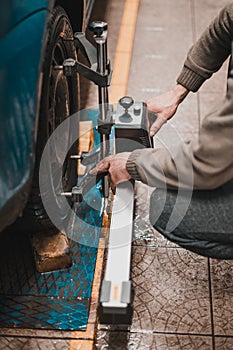 Close-up of a tire clamped by a leveler that passes the automatic alignment of the wheels in the garage, garage and