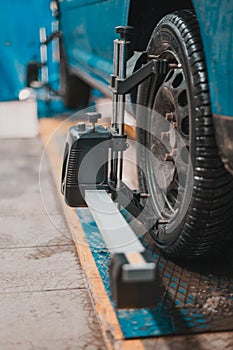 Close-up of a tire clamped by a leveler that passes the automatic alignment of the wheels in the garage, garage and