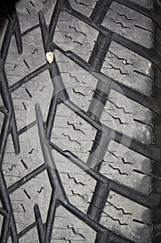 Close up of a tire treed with a rock in the grooves