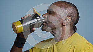 Close-up tired athletic man athlete taking break during training drinking cool fresh water from sports bottle quenches