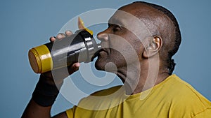 Close-up tired athletic man athlete taking break during training drinking cool fresh water from sports bottle quenches