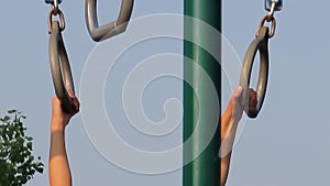 A close up to a kid hands playing at a playground using monkey bars.