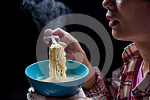 Young man hand pickup tasty noodles with steam and smoke in bowl