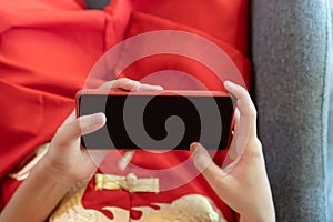 Close up to Mockup empty mobile screen in Asian Boy`s hand in Red China Suit Theme