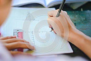 Close up to students writing.