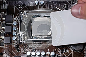 Close up to technician squeezing or application the thermal paste compound on the top of main cpu in the socket. Concept of