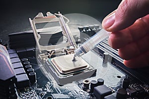 Close up to technician squeezing or application the thermal paste compound on the top of main cpu in the socket. Concept