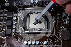 Close up to technician squeezing or application the thermal paste compound on the top of main cpu in the socket. Concept of