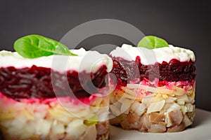 Close up to traditional layered fish salad with beetroot, potato, onion, herring and mayonnaise. Salad herring under fur coat