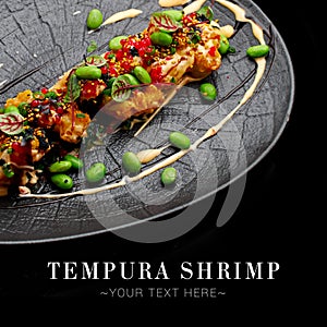 Close up to traditional Pan Asian Tempura shrimp dish served on oval plate isolated on black background. Ready advertising banner