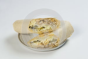 Close up to Two parts of chicken meat shawarma, isolated on background. Turkish donner wrapped in lavash bread