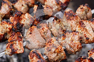 Close up of toasted shashlik on skewers. Succulent barbecue roasting on chargrill. Concept of picnic outdoor