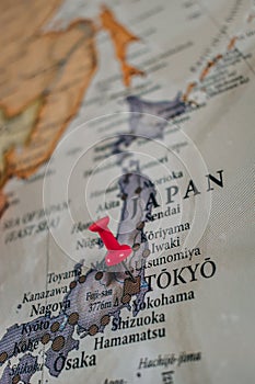 Close up of Tokyo pin pointed on the world map with a pink pushpin