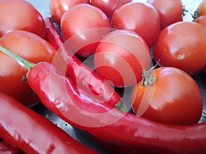 Close-up of tomatos and chilli peppers in red collor