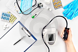 Close-up of tonometer by patients arm during blood pressure measuring at medical consultation