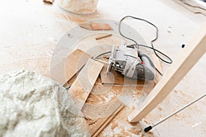 Close-up tools for cuts the laminate Board with an electrofret saw. installing new wooden laminate flooring. concept of photo