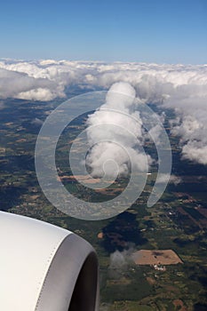 Close-up of top of airplane engine in flight over Canada with fluffy cloud