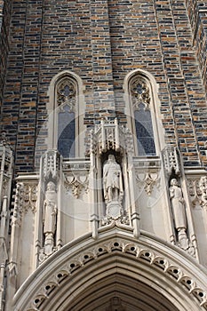 Close up of the top of the arched entryway and three statues above of the Duke University Chapel in Durham, North Carolina