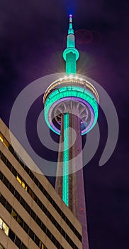 Close up top of CN tower at night. Smudgy clouds.