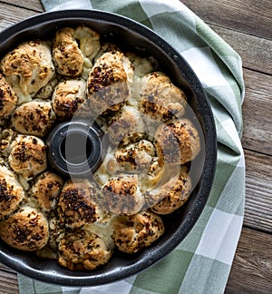 A close up top down view of a bundt pan filled with pull apart buns fresh out of the oven. Also known as monkey bread.