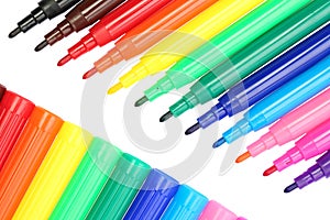 Close up, top down view of left open multicolored felt tip pens and their caps, isolated on white