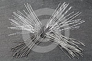 Close up, top down view of a set of four different types concrete reinforcement macro fibers - hooked end steel, white