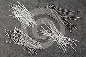 Close up, top down view of a set of four different types concrete reinforcement macro fibers - hooked end steel, white