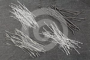 Close up, top down view of a set of four different types concrete reinforcement macro fibers - hooked end steel, white photo
