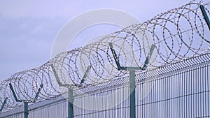 Close up of the top of the fence with barbed wire, prison