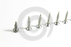 Close-up top shoot of multiple screws on white blurry background